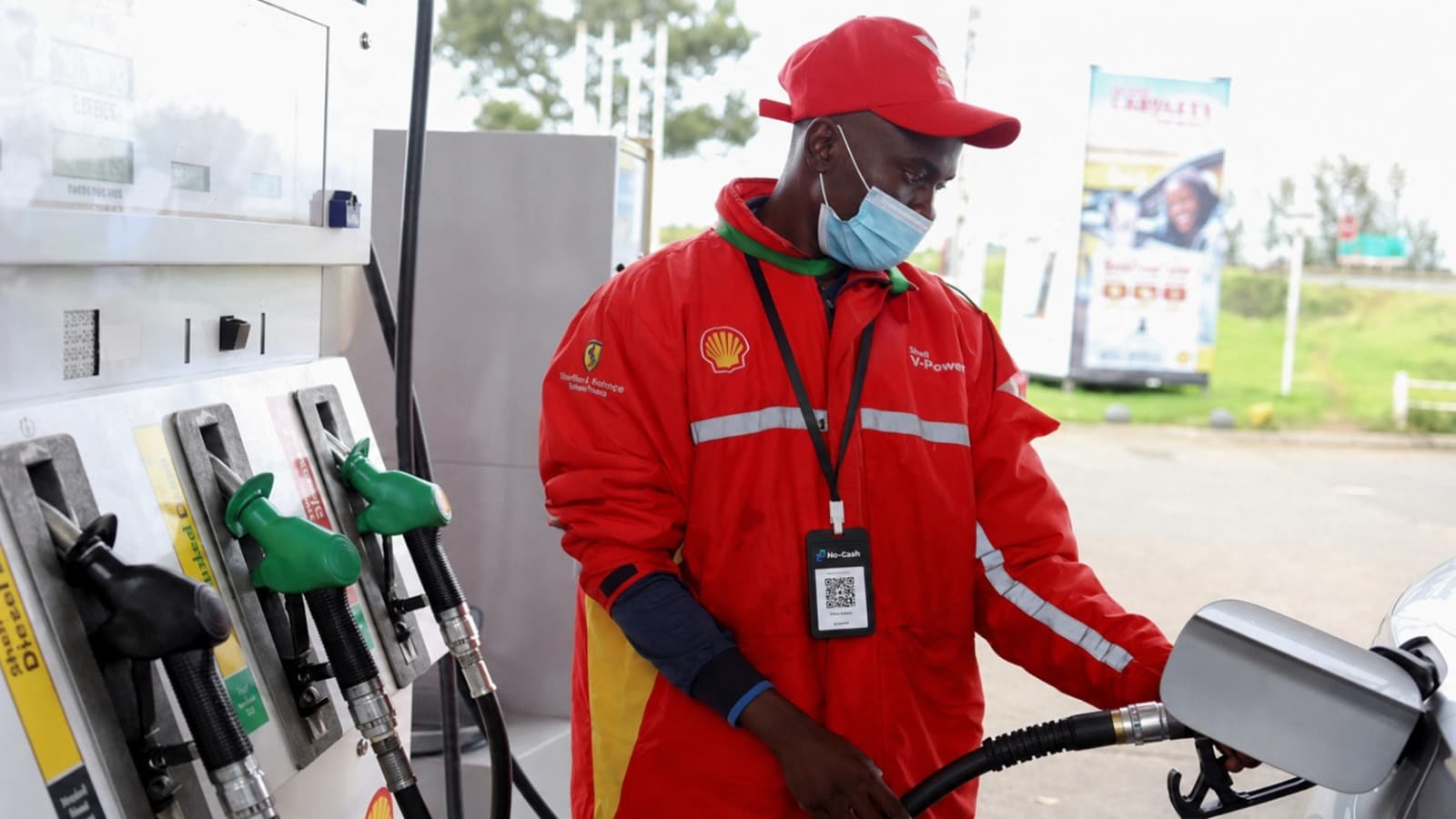 Petrol attendant wearing a NoCash QR code lanyard at a Shell forecourt