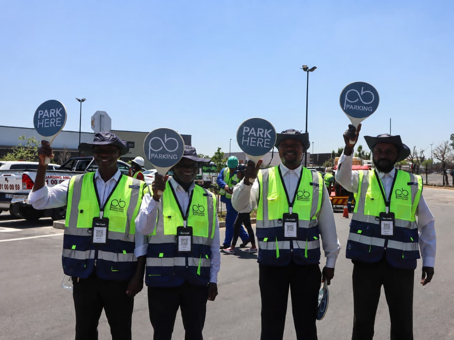 Parking attendants wearing NoCash QR code lanyards at a shopping centre